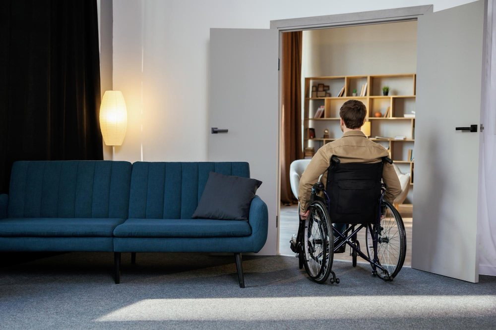 Un jeune homme en fauteuil roulant se déplace dans l'appartement